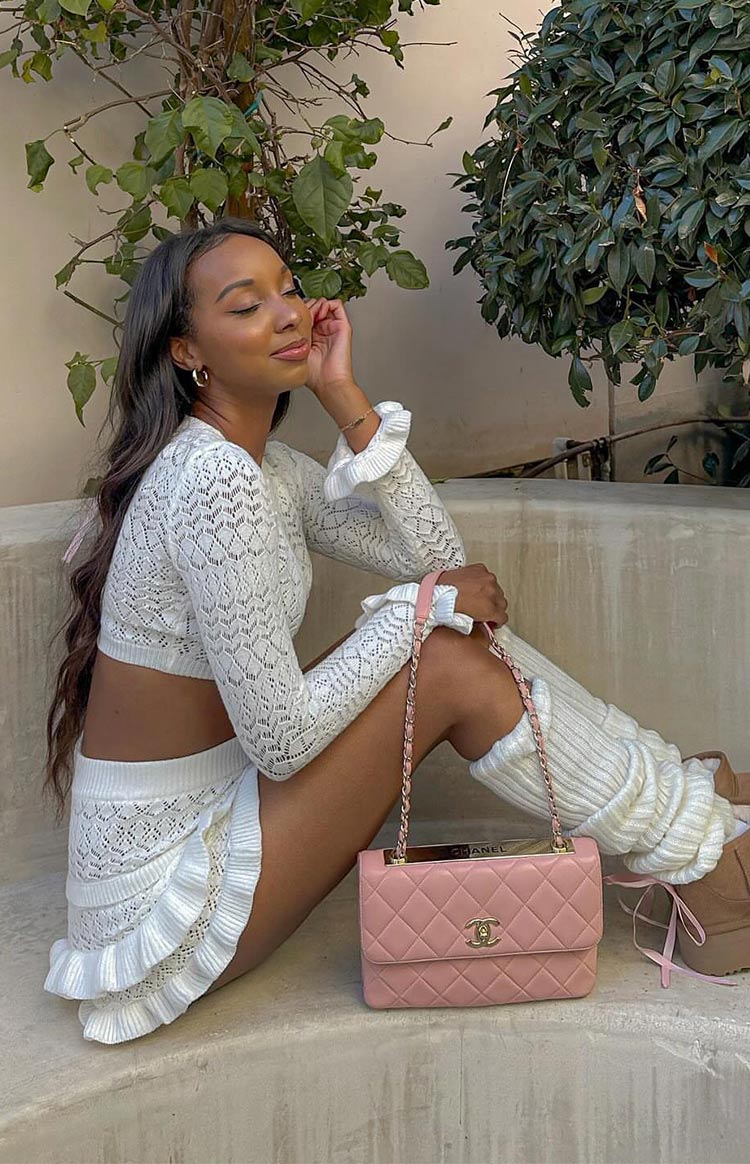Side view of white knit ruffle shorts with a layered ruffled hem and open-knit pattern