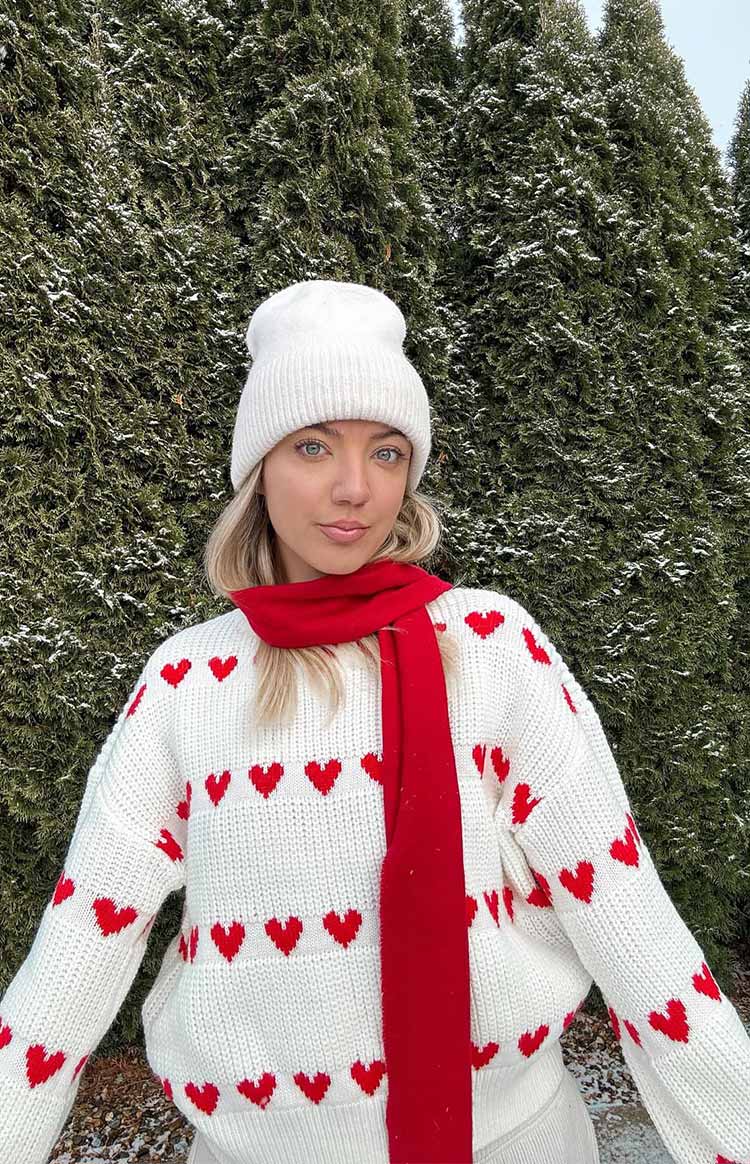 White chunky knit jumper with all-over red heart pattern and ribbed cuffs