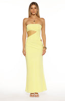 A full-length image of our model wearing a tight strapless yellow maxi dress. This maxi features significant cutouts on the left side of the torso exposing the waist and hip. The skirt of the dress is ruched slightly on the side and flows down to the floor.