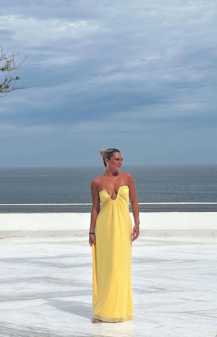 Full length view of a yellow strapless maxi dress with a deep U-shaped plunge neckline