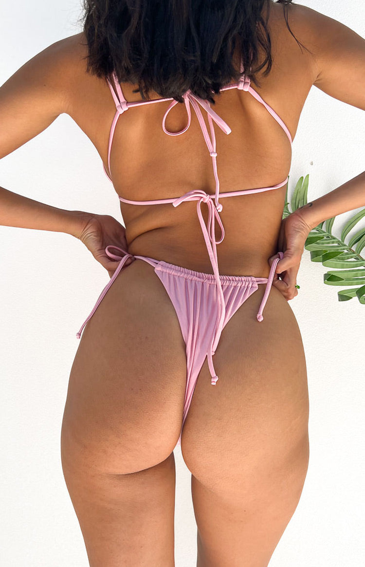 Rear view of the metallic pink bikini bottom with ruched thong style and adjustable tie sides