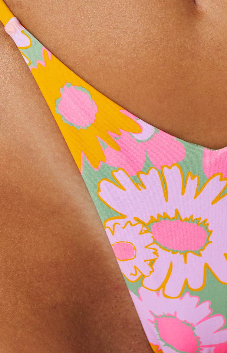 Close-up of the retro floral pattern on the bikini bottoms with pink, green, and orange flowers