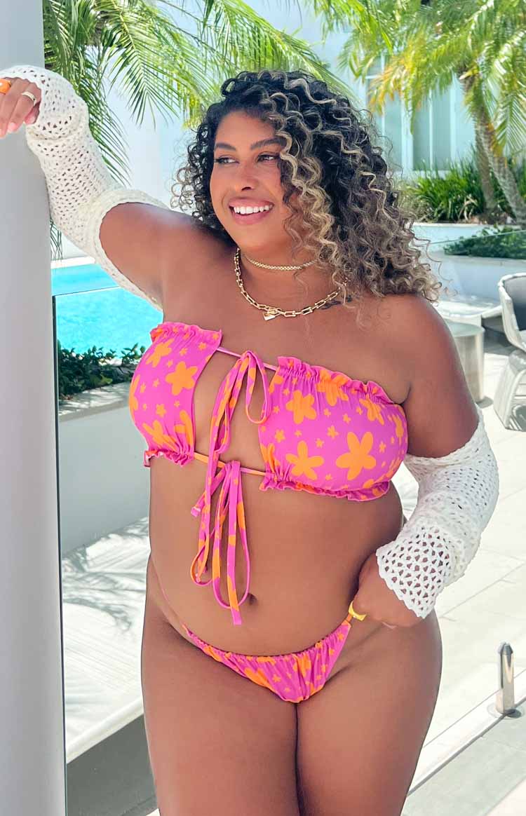 Front view of a pink bandeau bikini top with orange floral print, featuring a ruffled top edge and multiple front ties