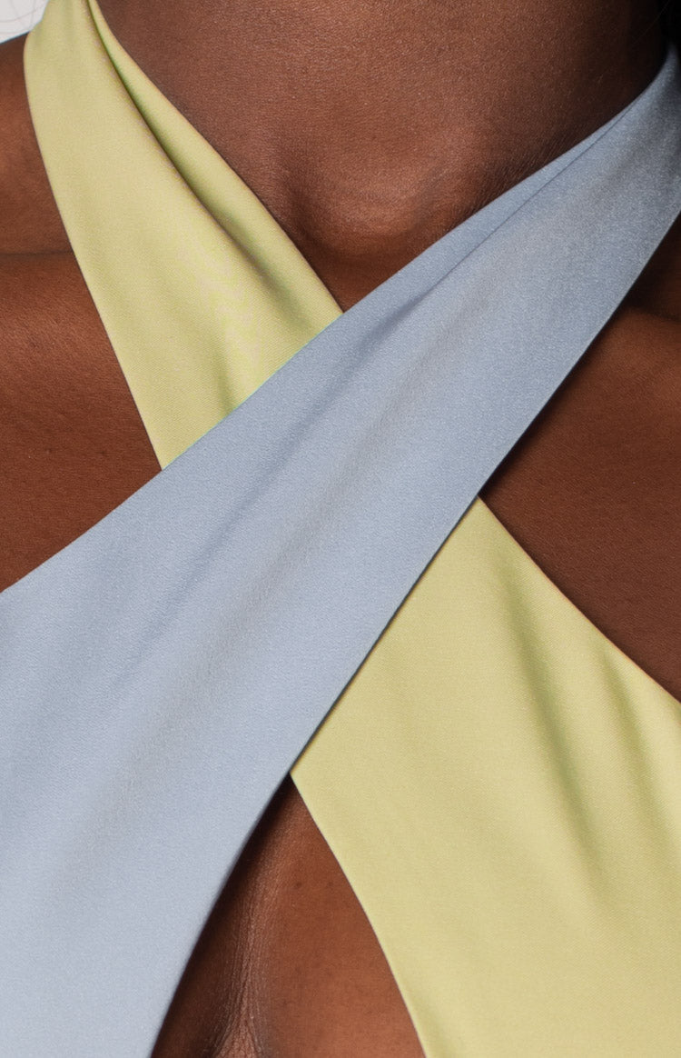 Close-up of the light green and light blue crossover halter neckline of the mini dress