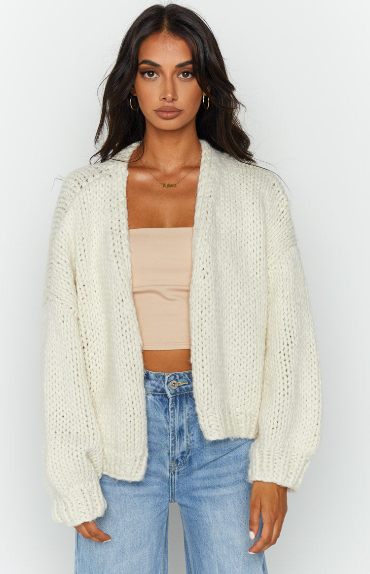 Close-up front view of a cream chunky knit cardigan with an open front and dropped shoulders
