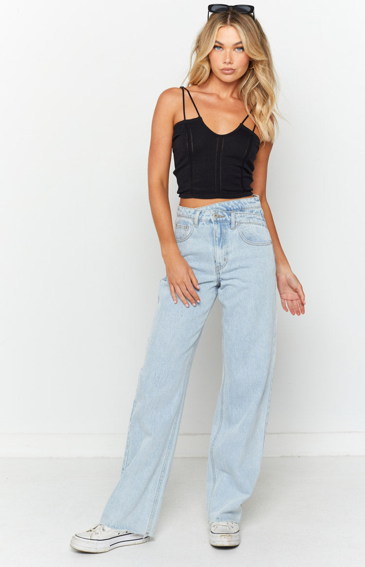Full front view of a black knit crop top with a V-neck, double spaghetti straps, and textured vertical panels