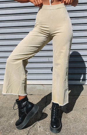 High-waisted beige corduroy wide-leg pants with a distinctive raw frayed hem