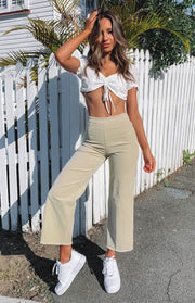 Beige corduroy wide leg pants with a high waist and frayed cropped hem