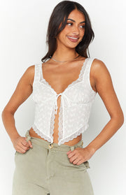 White broderie anglaise tie-front top with V-neck, wide straps, and scalloped lace trim