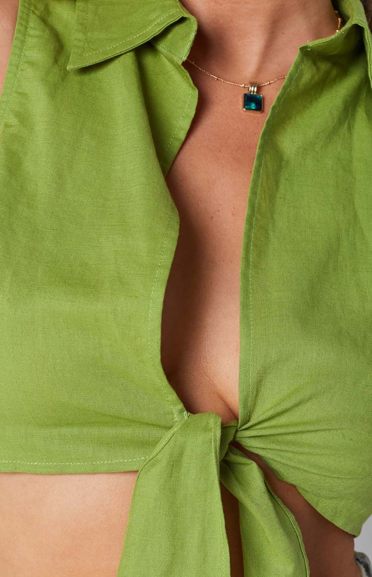 Close-up of the olive green tie-up shirt showing the front knot detail and open collar