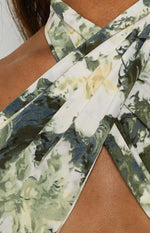 Criss-cross neckline of a multi-colour abstract print scarf top in shades of green, white, and yellow