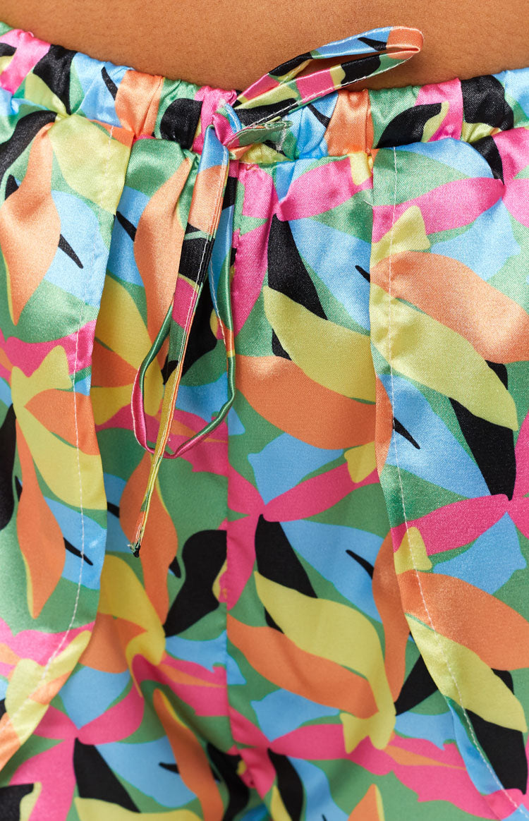 Gathered elasticated waistband with a tied drawstring on vibrant tropical leaf print satin shorts