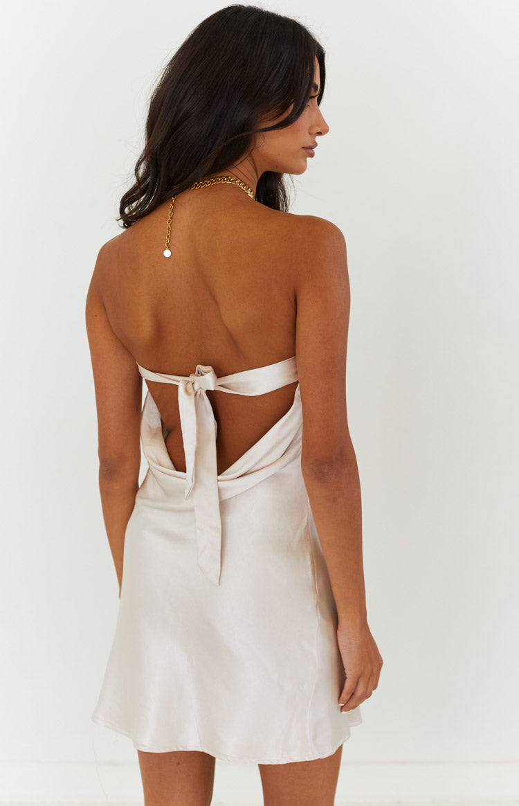 Rear view of a cream strapless mini dress with an open back and a tie closure
