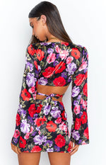 Rear view of the black satin floral top with red and purple flowers, featuring a cut-out back and tie closure