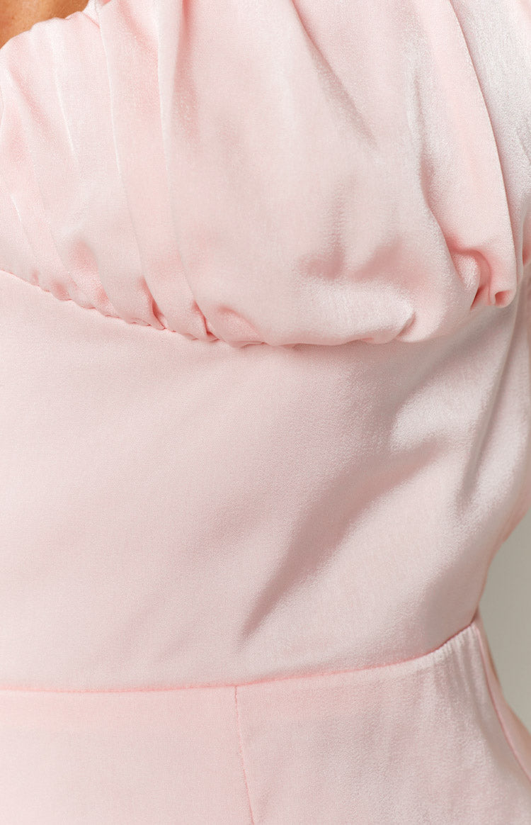 Close-up of the ruched bodice and waist seam of a light pink mini dress