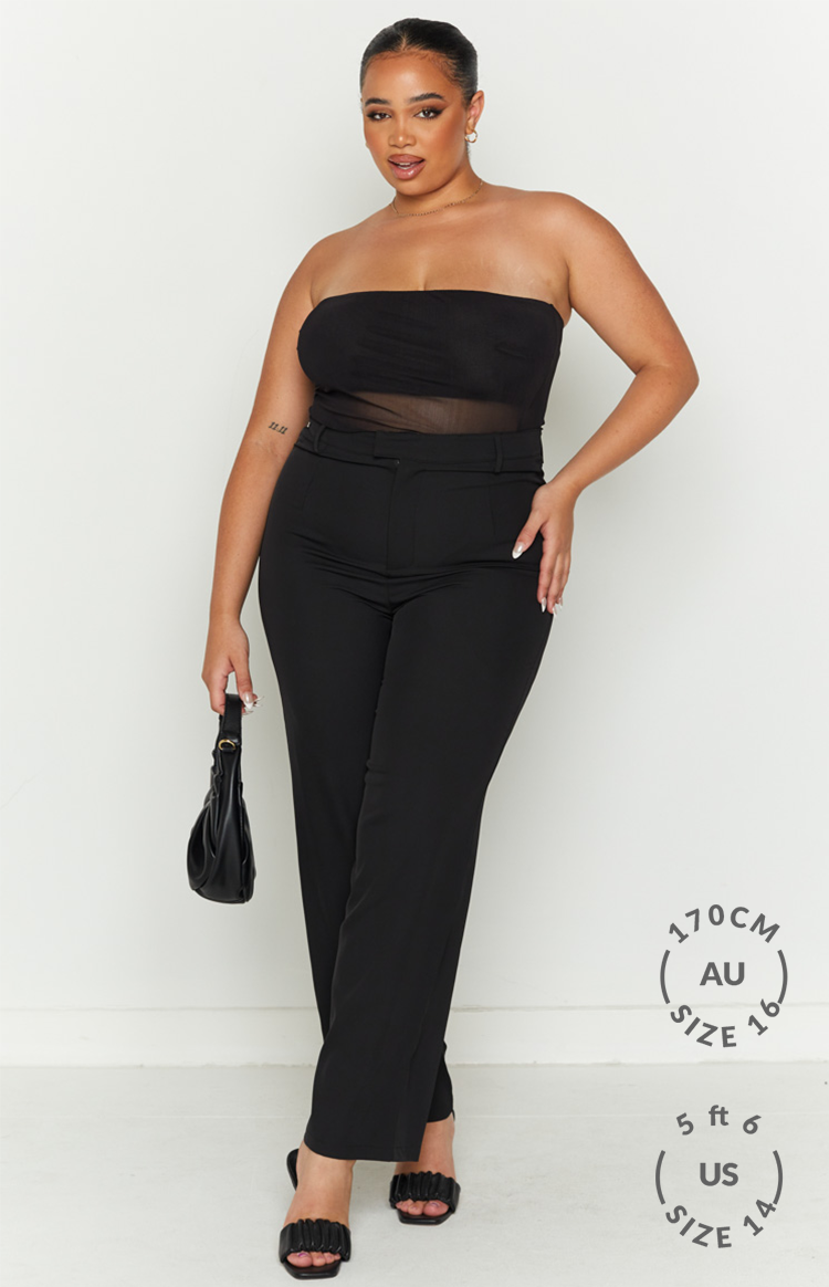 Full length view of a black strapless bandeau top with a ruched bust and sheer mesh midriff panel