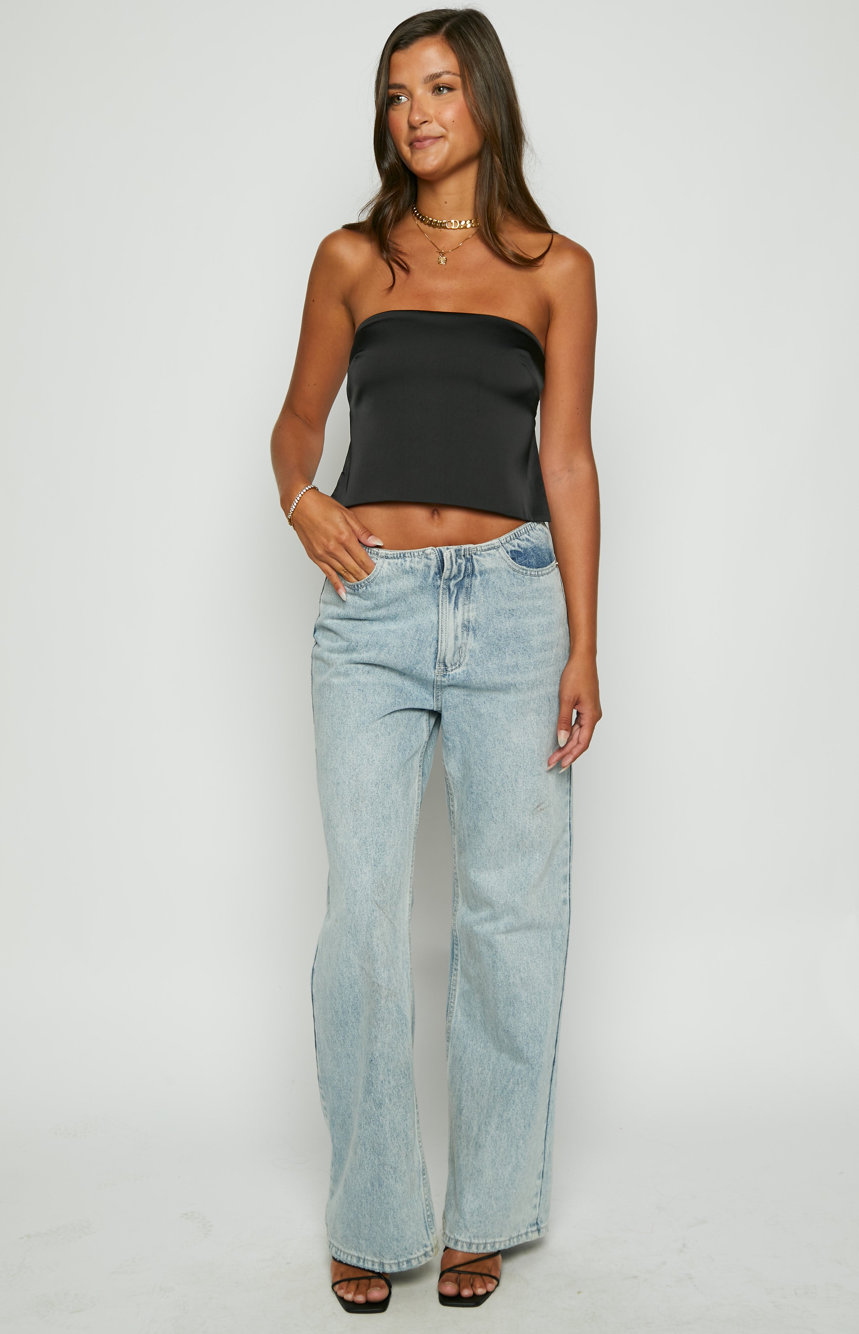 Front view of a black satin strapless top with a relaxed, cropped fit and smooth, lustrous fabric