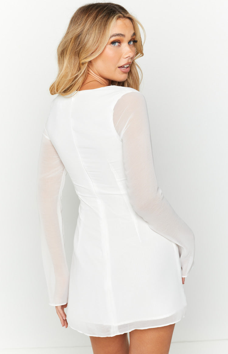 Rear view of a white long sleeve mini dress with sheer sleeves and a fitted bodice