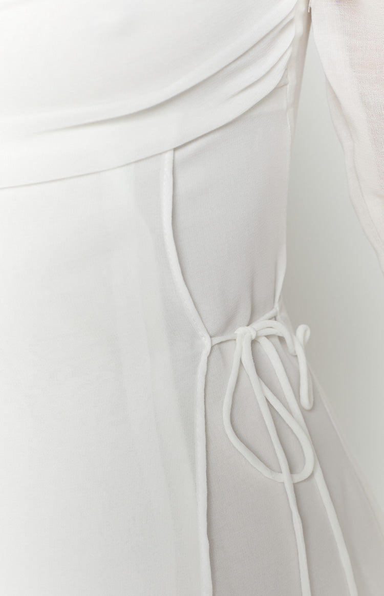 Side view showing the adjustable drawstring detail and ruched fabric of the white mini dress