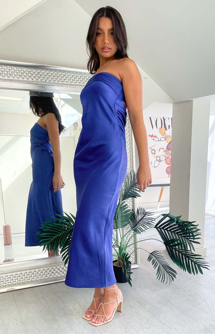 Side view of a navy strapless maxi dress showing the draped neckline and fitted silhouette