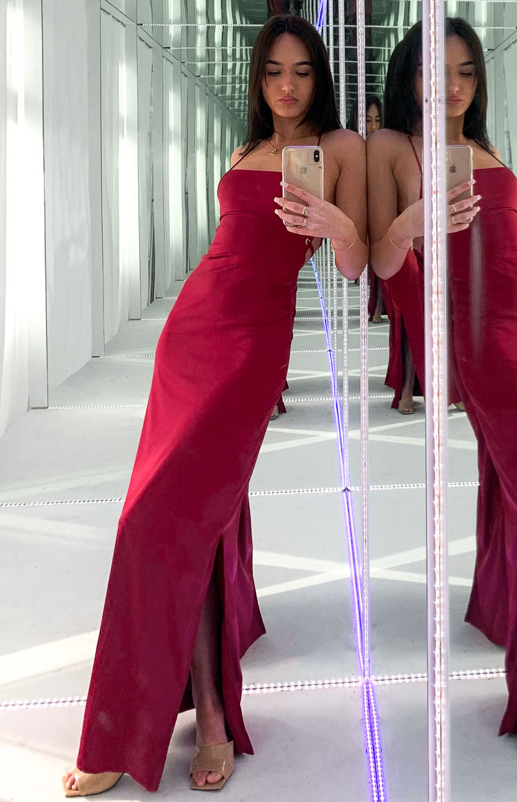 Wine red satin maxi dress with a straight neckline, thin criss-cross back straps, and a high side slit