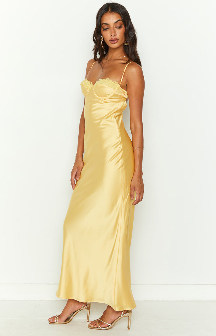 Side view of a yellow satin midi dress showing the lace-trimmed bust and flowing skirt