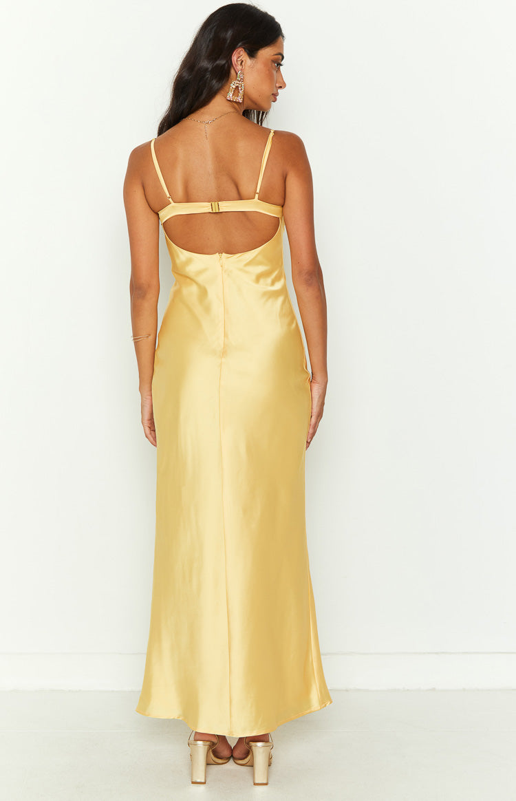 Back view of a yellow satin midi dress with thin spaghetti straps, a low cut back, and an adjustable clasp closure