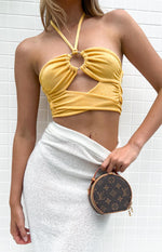 Close-up of the yellow halter top showing the silver ring detail, ruched fabric, and front cutout
