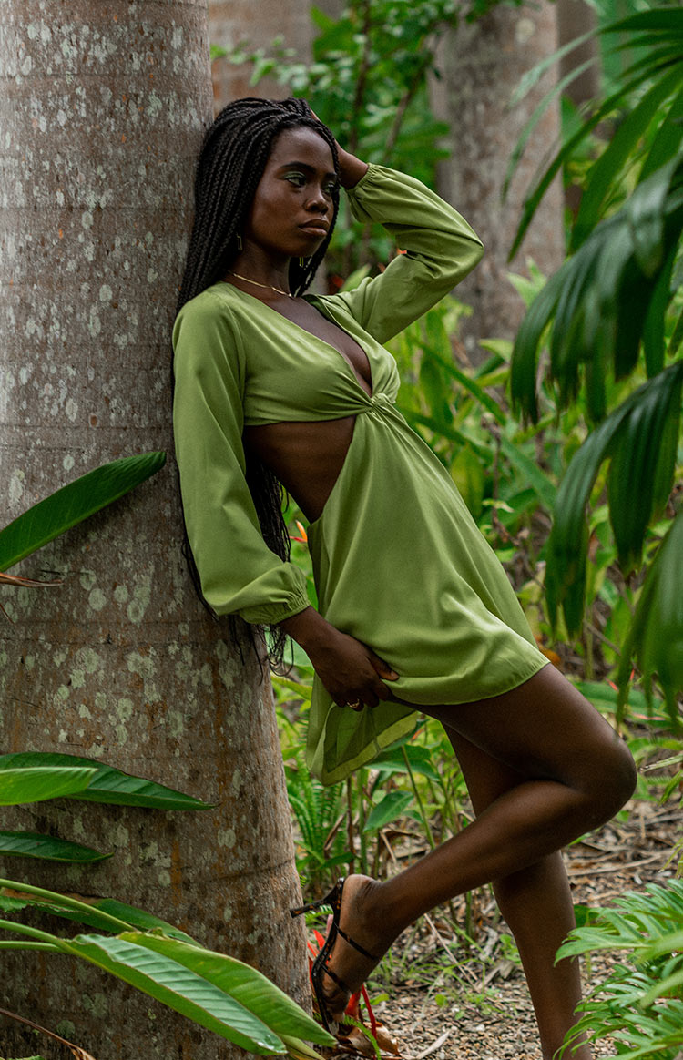 Mini dress in sage green with side waist cutouts, a twisted bust, deep V-neck, and long balloon sleeves