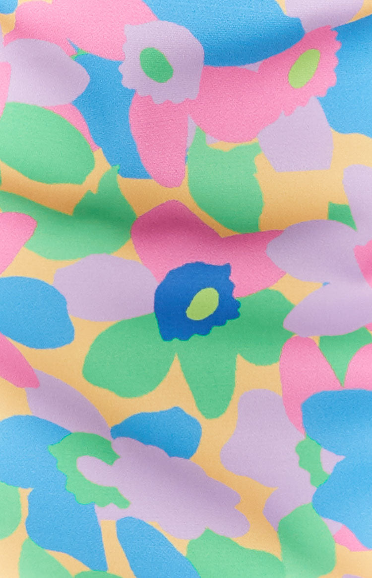 Close-up of the multi-coloured abstract floral print in pink, green, blue, and lavender on a yellow bralette top