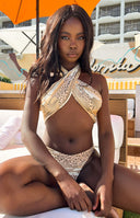 Front view of the beige and brown animal print criss-cross halter top and matching high-cut bikini bottom
