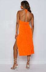 Rear view of the orange textured midi dress, showing the halter neck tie, open back, and high side slit