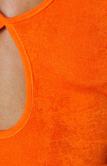 Close-up of the orange textured knit fabric and a rounded cutout detail
