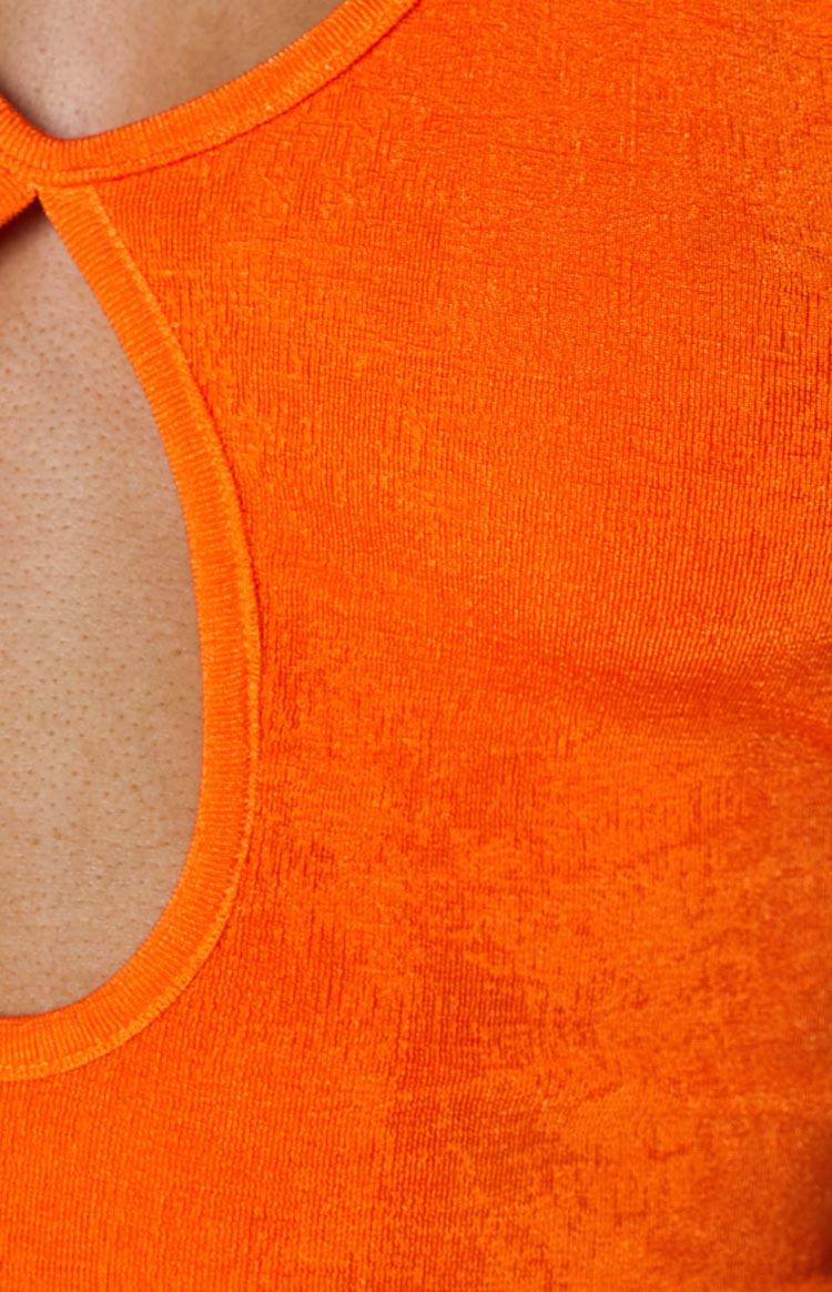 Close-up of the orange textured knit fabric and a rounded cutout detail