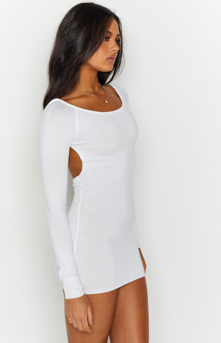 Side view showing the large side cutout and long sleeves of a white knit mini dress