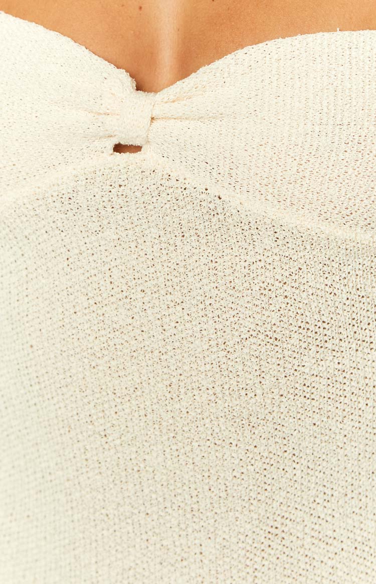 Close-up of the cream knit bust detail with a central knot and small cutout
