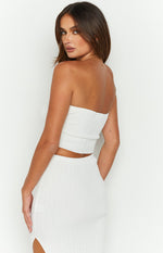 Rear side view of a white ribbed knit bandeau top with a straight back and cropped hem