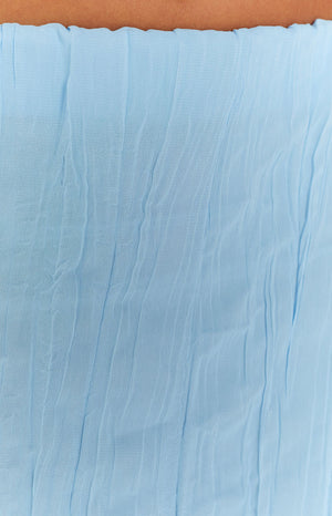 Close-up showing the light blue crinkled texture of the maxi skirt and the ruffled elastic waistband