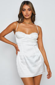 Structured bustier bodice of a white satin mini dress with delicate lace trim and thin spaghetti straps