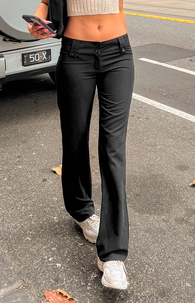 Front view of black low waist pants with a double button and hook closure and a straight leg silhouette