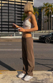 Side view of taupe low waist straight leg pants showing the relaxed fit and full length