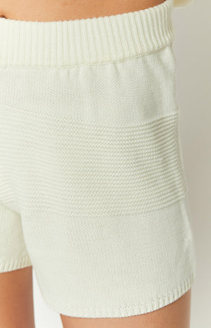 Close-up of the ribbed waistband and textured knit pattern on white shorts