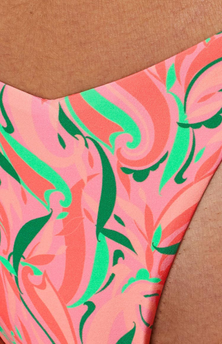 Close-up of the vibrant orange, pink, and green abstract swirl pattern on the bikini bottoms