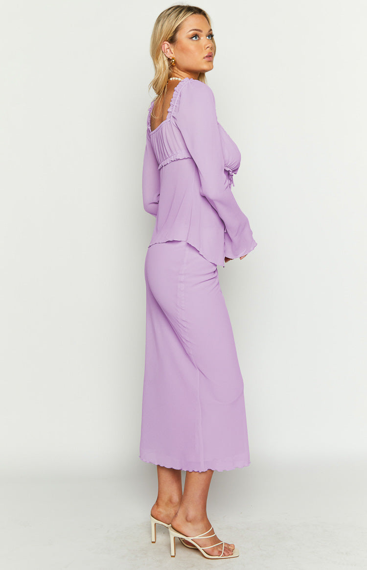 Side view of a lilac maxi skirt with a fitted silhouette and a wavy hem