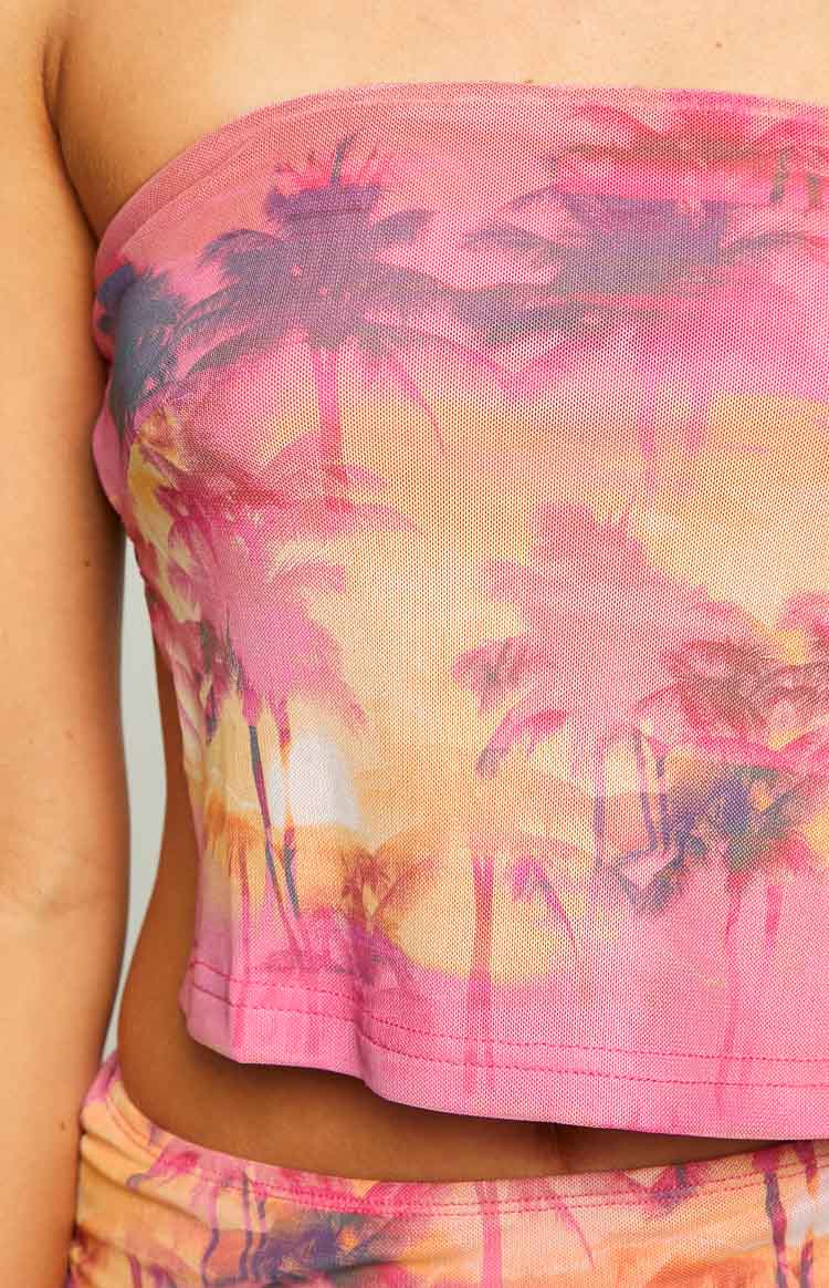 Close-up of the sheer pink mesh strapless top, highlighting the vibrant sunset palm tree print